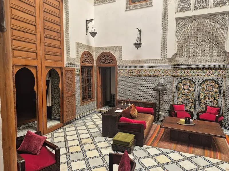 Cour intérieure d’un riad traditionnel au Maroc avec piscine et décoration marocaine authentique
